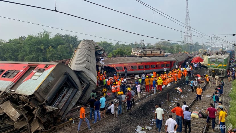 Petugas penyelamat mencari korban selamat di lokasi kecelakaan tabrakan kereta api di dekat Balasore, sekitar 200 km dari ibu kota negara bagian Bhubaneswar, India, pada Sabtu 3 Juni 2023. (Foto: AFP/Dibyangshu Sarkar)