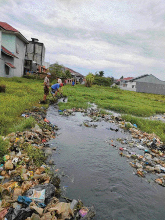 GOTONG ROYONG: Warga Kompleks Permata Suraugadang (PSG) Kelurahan Suraugadang melakukan kegiatan gotong royong mengangkat sampah yang menumpuk di drainase dan sawah, kemarin.(IST)