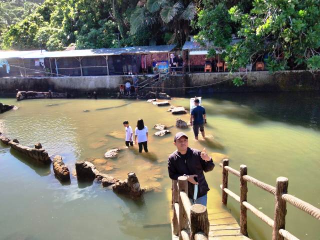 Wisatawan berfoto dengan latar belakang batu Malin Kundang di Pantai Air Manis Kota Padang, yang kini sudah menjadi seperti kolam.