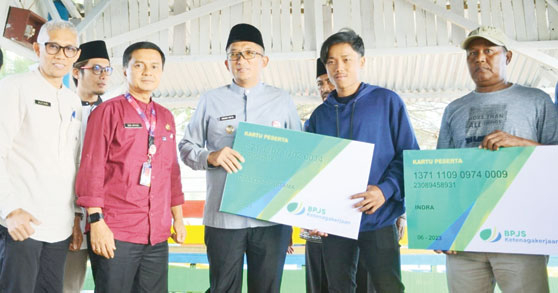 PEDULI: Wako Hendri Septa menyerahkan kartu BPJS Ketenagakerjaan secara simbolis kepada perwakilan nelayan di Kampung Nelayan Pasie Nantigo, Jumat (22/9).(IST)