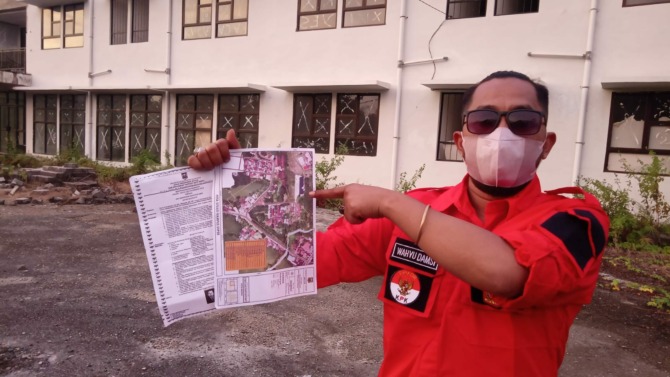 POLEMIK: Anggota Kaum Suku Chaniago Bukik Nagari Muaro, Wahyu Burmas memperlihatkan peta lokasi dan berkas pengajuan IMB di depan Gedung Rusunawa Nagari Muaro, kemarin.(YULICEF ANTHONY/PADEK)