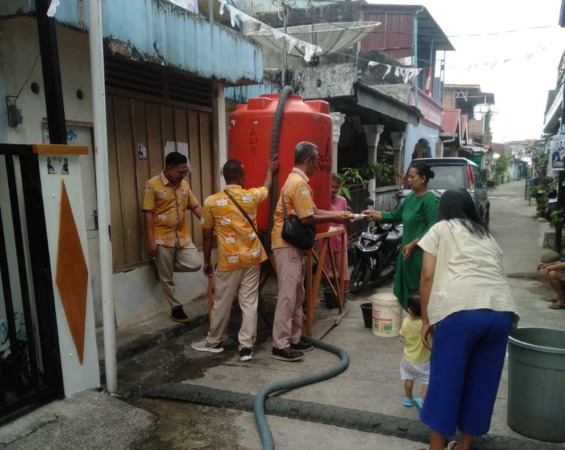 Demi Pelanggan: Petugas Perumda Air Minum Kota Padang menyalurkan air bersih dengan tangki kepada pelanggan di kawasan Pegambiran Kecamatan Lubukbegalung kemarin. (IST)