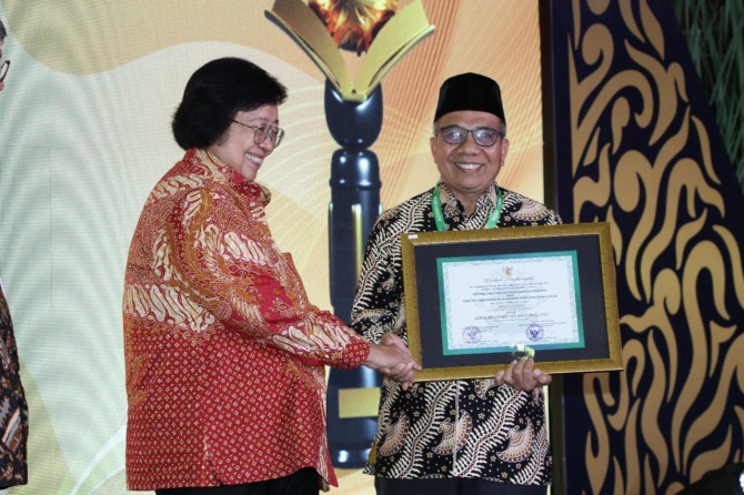 PRESTASI: Kepala SMAN 2 Painan Erisman menerima piagam penghargaan sebagai Sekolah Adiwiyata Nasional dari Menteri LHK RI, Siti Nurbaya.(DOK SMAN 2 PAINAN)