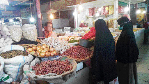 LAYANI PEMBELI: Salah seorang pedagang sembako di Pasar Raya Padang sedang melayani pembeli di tokonya, Selasa (10/10).(MUFIDA NUR HUSNI/PADEK)
