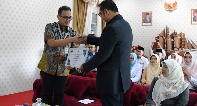 Kepala Unit CSR PT Semen Padang Dedi M Sidiq menerima Piagam Penghargaan dari Bupati Epyardi Asda (kanan).