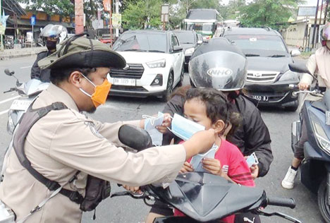 BAGI-BAGI MASKER: Personel BPBD Kota Padang membagikan masker kepada pengendara sepeda motor di kawasan Pasar Alai, Kamis (5/10).(IST)