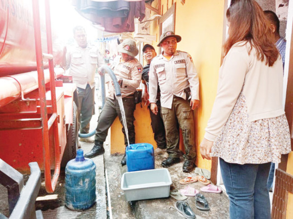 PENYALURAN: Petugas BPBD Kota Padang menyalurkan air bersih kepada masyarakat di salah satu daerah di Kota Padang, Selasa (10/10).(IST)