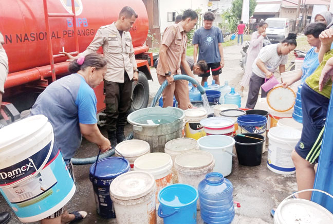 PENDISTRIBUSIAN: Petugas BPBD Kota Padang mendistribusikan air bersih kepada warga yang terdampak kekeringan di Kelurahan Matoaie, Kecamatan Padang Selatan, kemarin.(IST)