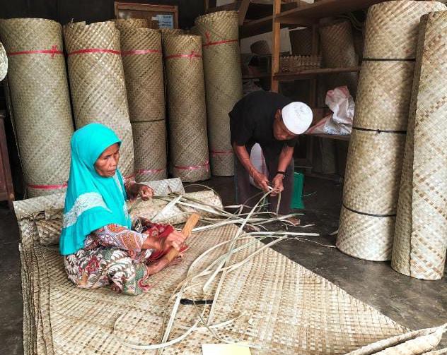 TEKUN: Yuliniwati sedang menyelesaikan proses pembuatan lapiak pandan yang dikerjakan secara manual.(YULICEF ANTONI/PADEK)