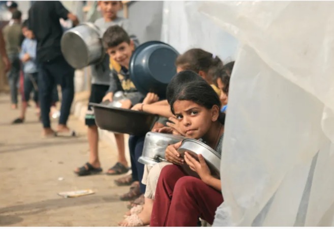 Anak-anak pengungsi Palestina yang meninggalkan rumah mereka di Jalur Gaza utara karena pemboman militer Israel yang intens menunggu makanan di Khan Younis, 11 November 2023. (Foto: Mahmud Hams/AFP)