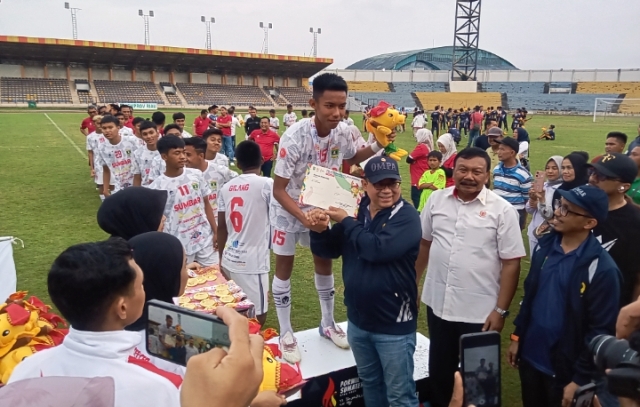 Ketua KONI Sumbar, Ronny Pahlawan mengalungkan medali emas kepada pemain sepakbola Sumbar.