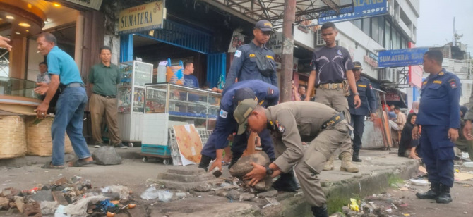 PEMBERSIHAN: Personel Satpol PP Kota Padang dan Disdag Kota Padang membersihkan puing-puing bekas lapak PKL di kawasan Pasar Raya Barat, kemarin.(SATPOL PP KOTA PADANG FOR PADEK)
