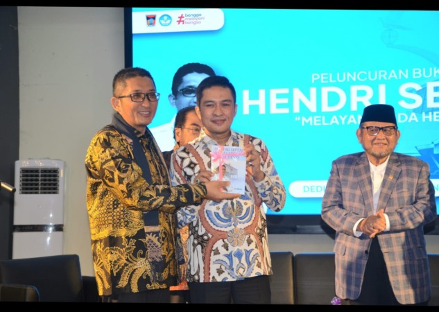 INSPIRATIF: Wako Hendri Septa menyerahkan buku biografinya kepada Wawako Ekos Albar saat peluncuran, Rabu (27/12) malam. (PROKOPIM PADANG)