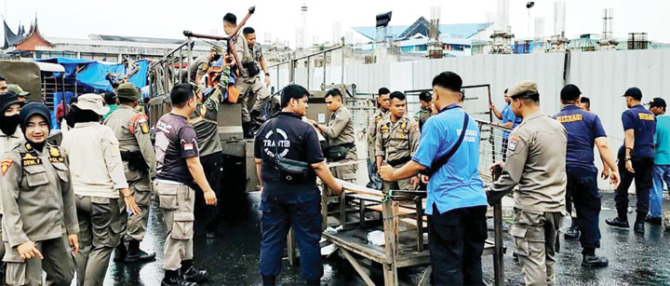 MELANGGAR: Personel Satpol PP Kota Padang menertibkan barang-barang milik PKL yang berada di kawasan Pasar Raya Barat sampai Jalan Permindo, Rabu (6/12).(SATPOL PP KOTA PADANG FOR PADEK)