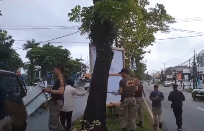 Satuan Polisi Pamong Praja Kota Padang melanjutkan penertiban iklan yang melanggar aturan, termasuk baliho, spanduk dan poster caleg di tiang listrik, tiang telepon, rambu-rambu jalan, ruang hijau, maupun yang dipaku di batang pohon, Sabtu (6/1/2024). (Fo
