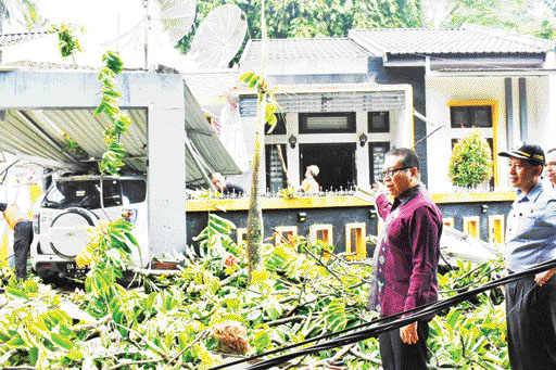MUSIBAH: Pj Wako Payakumbuh Jasman meninjau pohon tumbang yang menimpa rumah warga di Payobasuang, Kota Payakumbuh, kemarin.(DISKOMINFO PEMKO PAYAKUMBUH UNTUK PADEK)