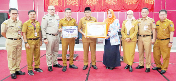 PRESTASI: Wako Hendri Septa menerima penghargaan dari Kepala Perwakilan BKKBN Sumatera Barat Fatmawati, Selasa (9/1).(PROKOPIM PADANG FOR PADEK)