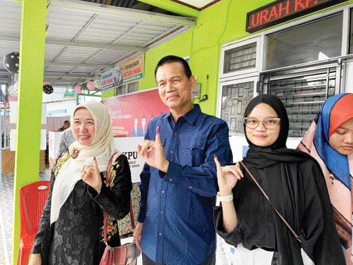 SALURKAN HAK: Genius Umar bersama istri dan anaknya usai mencoblos (foto kiri), kemarin. (foto kanan) Mardinson bersama keluarga memasukkan surat suara yang dicoblosnya ke dalam kotak suara.(ZIKRINIATI/PADEK)