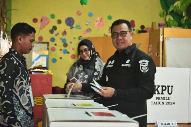 GUNAKAN HAK: Pj Wako Sawahlunto Zefnihan bersama istri, Erly Wirdayani Zefnihan melakukan pencoblosan surat suara di TPS dekat Rumah Dinas Walikota Sawahlunto, kemarin.(DOK KOMINFO SIJUNJUNG FOR PADEK)