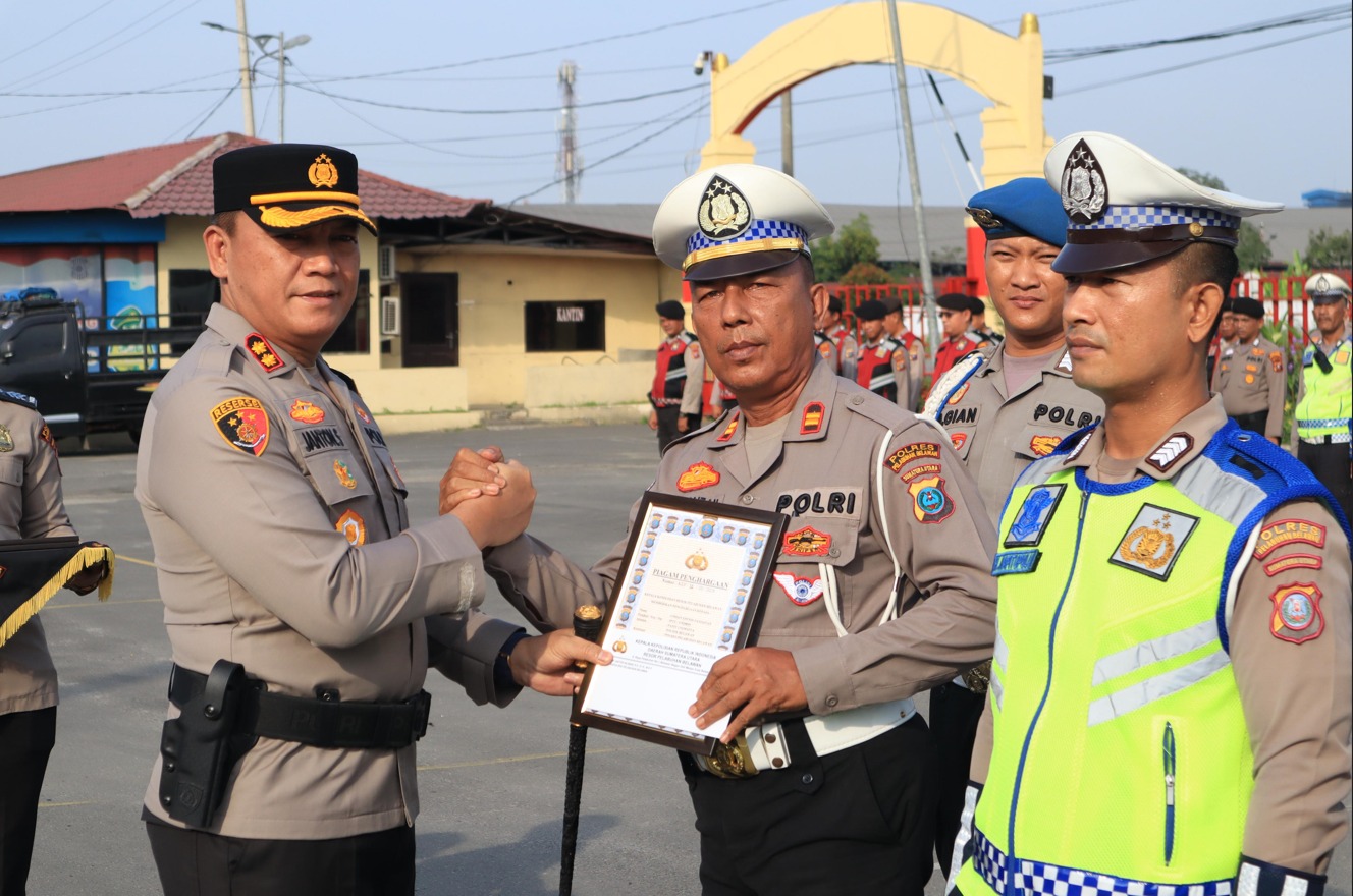 BERIKAN: Kapolres Pelabuhan Belawan AKBP Janton Silaban, SH., SIK., MKP., memberikan penghargaan kepada personel Polres Pelabuhan Belawan yang telah menunjukkan integritas dan prestasi