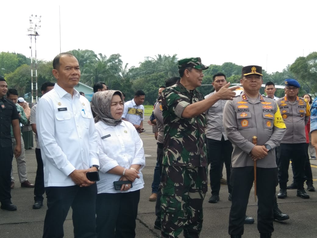 SAKSIKAN: Sekda Langkat, Amril (kiri) menyaksikan harimau sumatera dibawa menggunakan helikopter untuk dilakukan pelepasliaran ke TNGL.