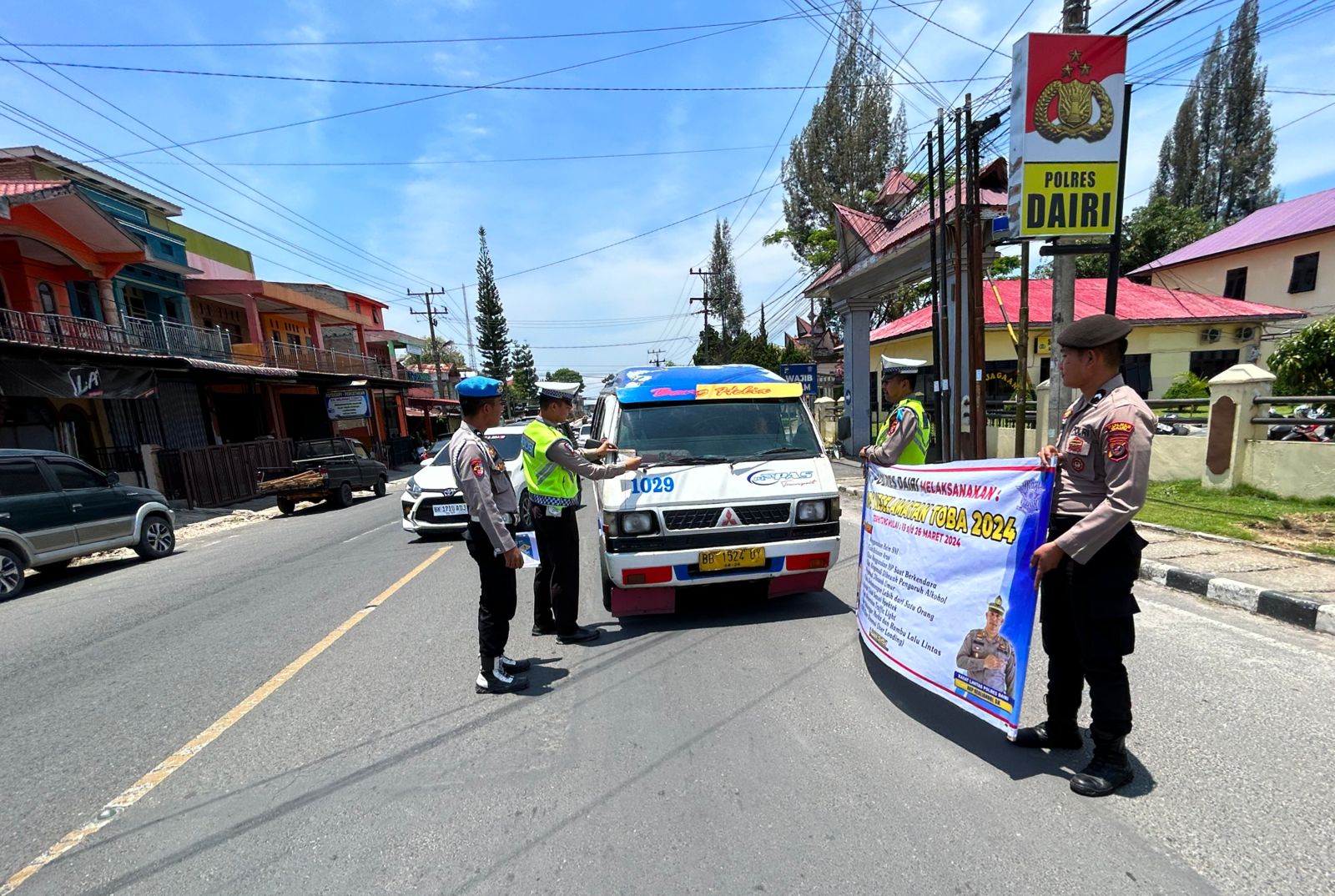 SOSILISASI: Anggota Satlantas Polres Dairi melalukan sosialisasi Operasi Keselamatan Toba 2024 kepada pengendara saat melintas dari depan Mapolres Dairi di Jalan Sisingamangaraja, Sidikalang,