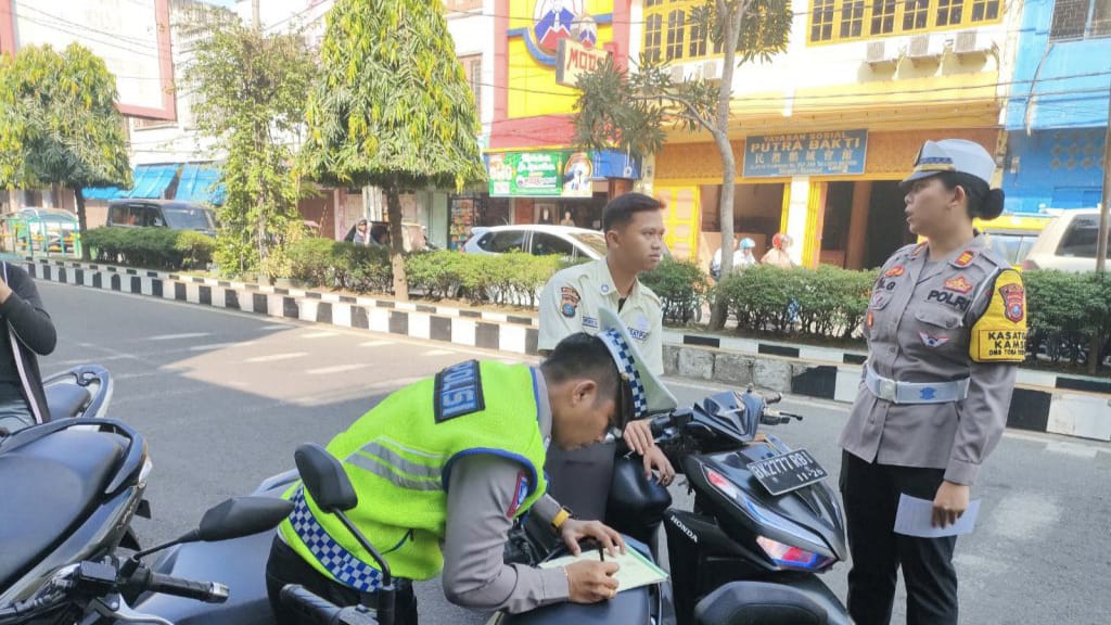 IMBAU: Kasat Lantas Polres Binjai, AKP Agus Ita Lestari Ginting (kanan) saat memberikan imbauan kepada pengendara dalam Operasi Keselamatan Toba. Satlantas Polres Binjai/Sumut Pos.