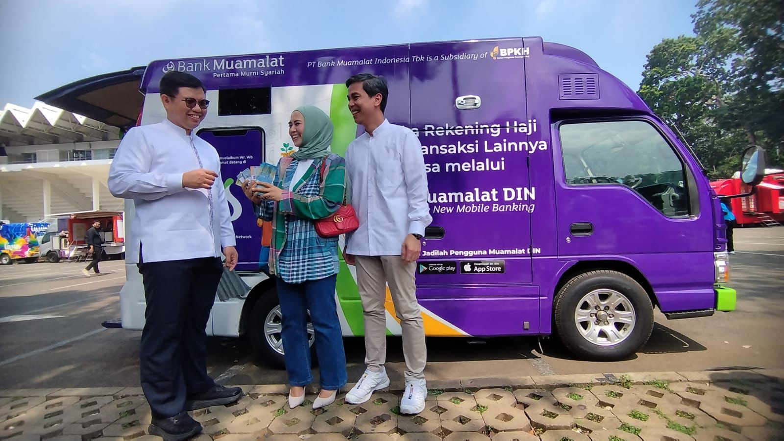 TUKAR UANG: Direktur Utama PT Bank Muamalat Indonesia Tbk Indra Falatehan (kiri) dan Sekretaris Perusahaan Bank Muamalat Hayunaji (kanan) berfoto bersama masyarakat yang menukarkan uang rupiah.