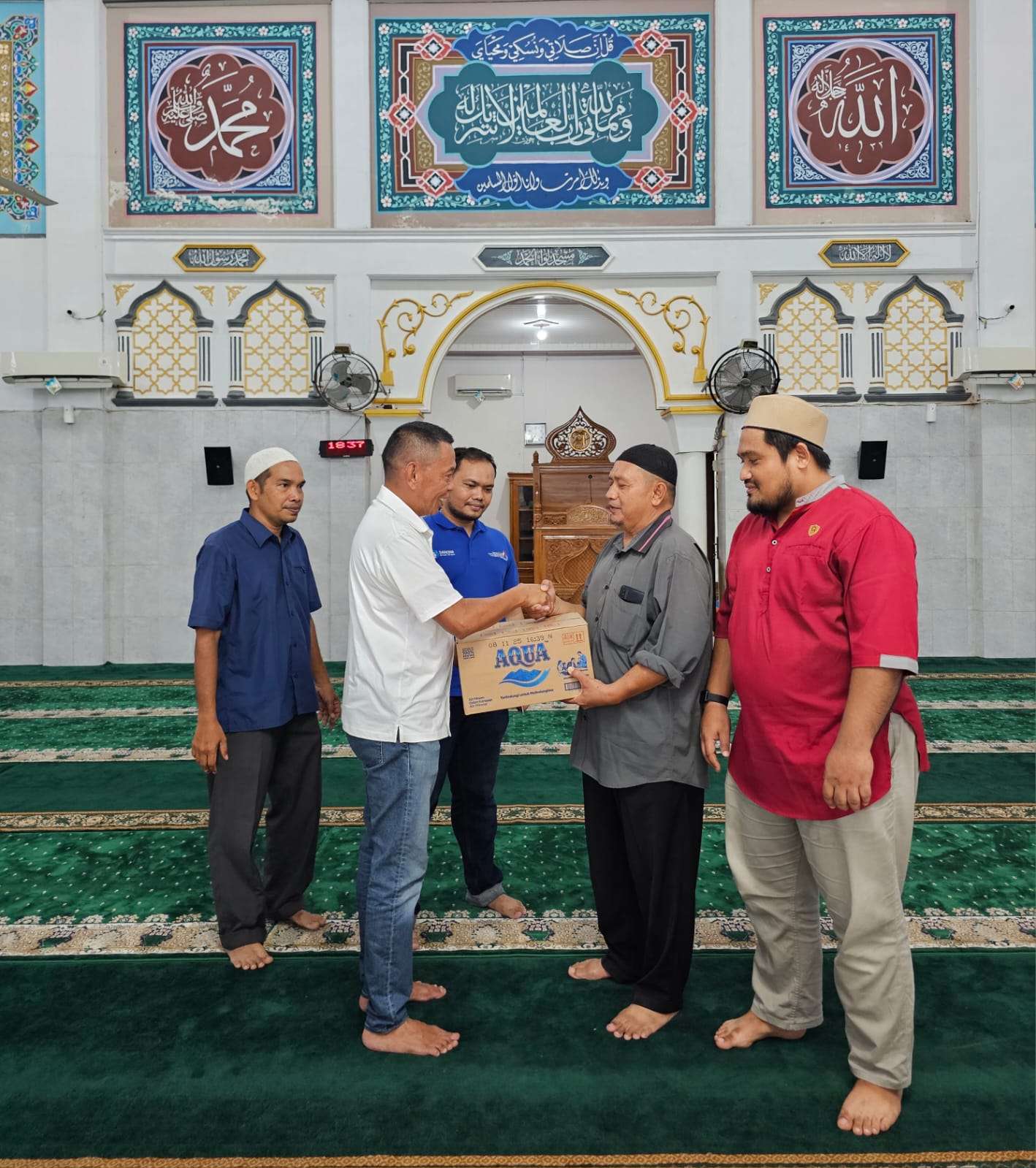 SALURKAN: Corporate Communication AQUA, Michael Liemena saat menyalurkan produk AQUA di Masjid Liwaul Hamdi di Aceh.