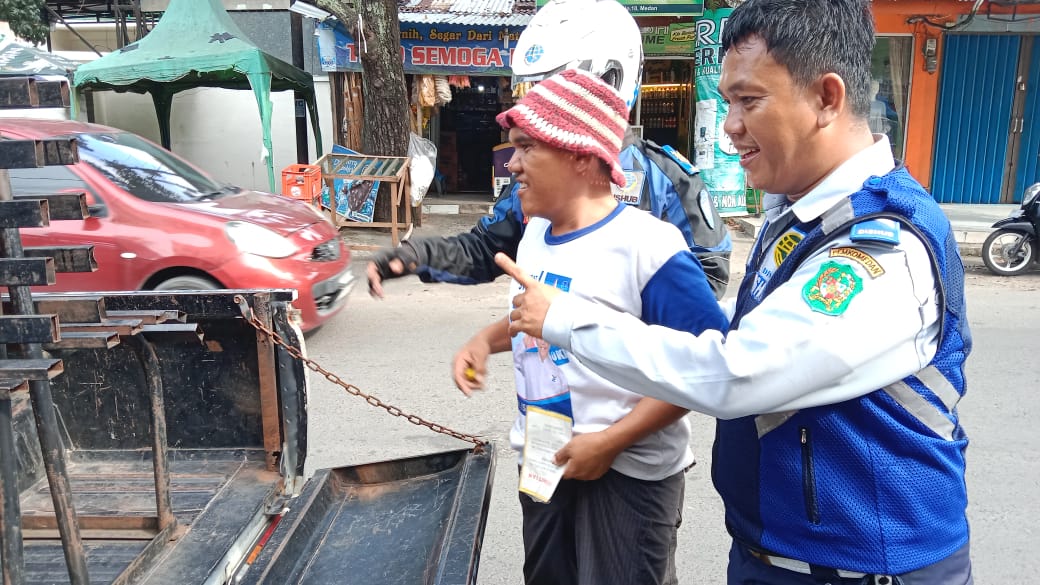 DIAMANKAN: Petugas Dishub Medan mengamankan pelaku pungli parkir di kawasan tepi jalan.