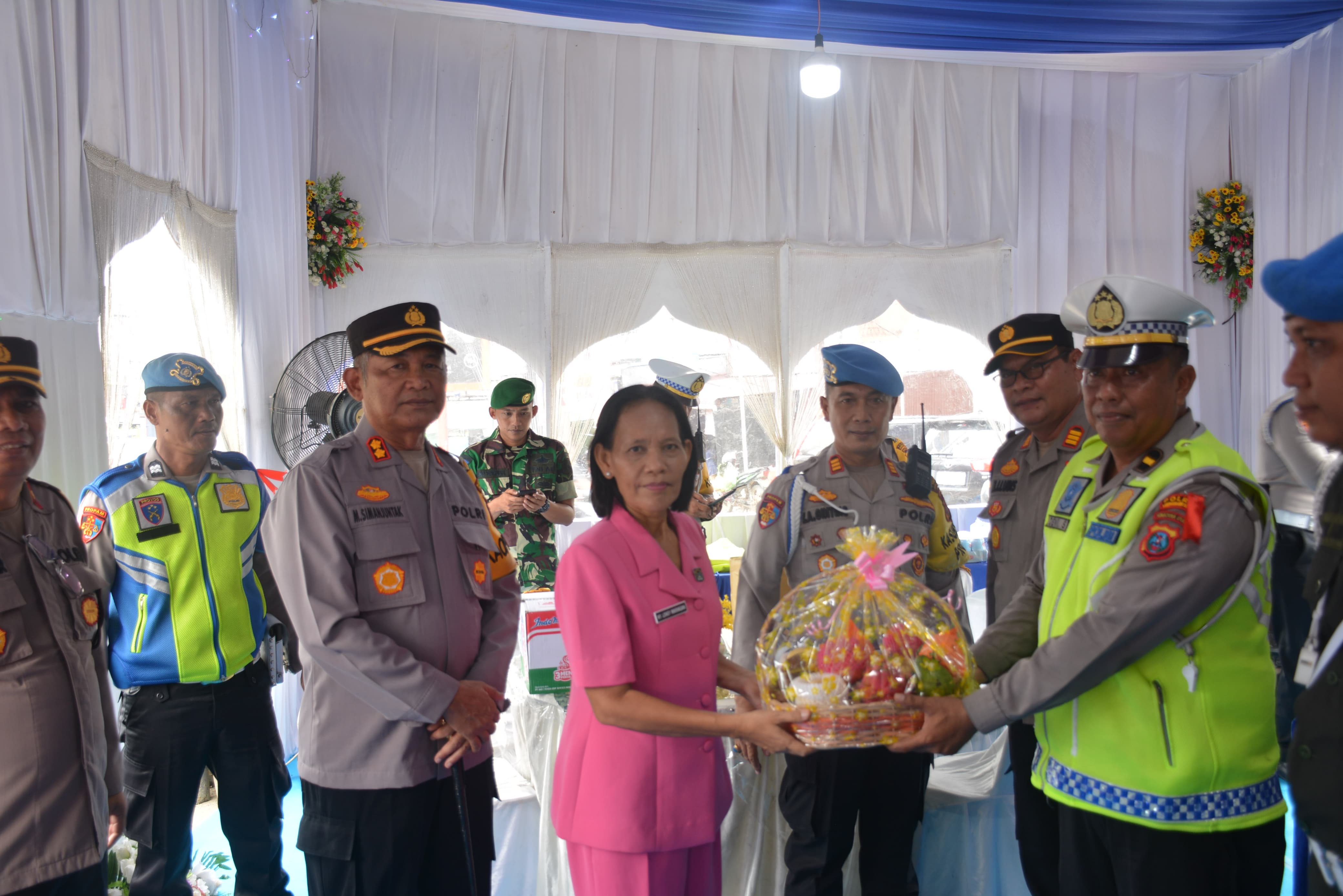 BERIKAN: Kapolres Labusel, AKBP Maringan Simanjuntak bersama Ketua Bhayangkari Cabang Polres Labusel, Ny Lensy Maringan Simanjuntak menyerahkan bingkisan kepada petugas Pos Pam II Torgamba.
