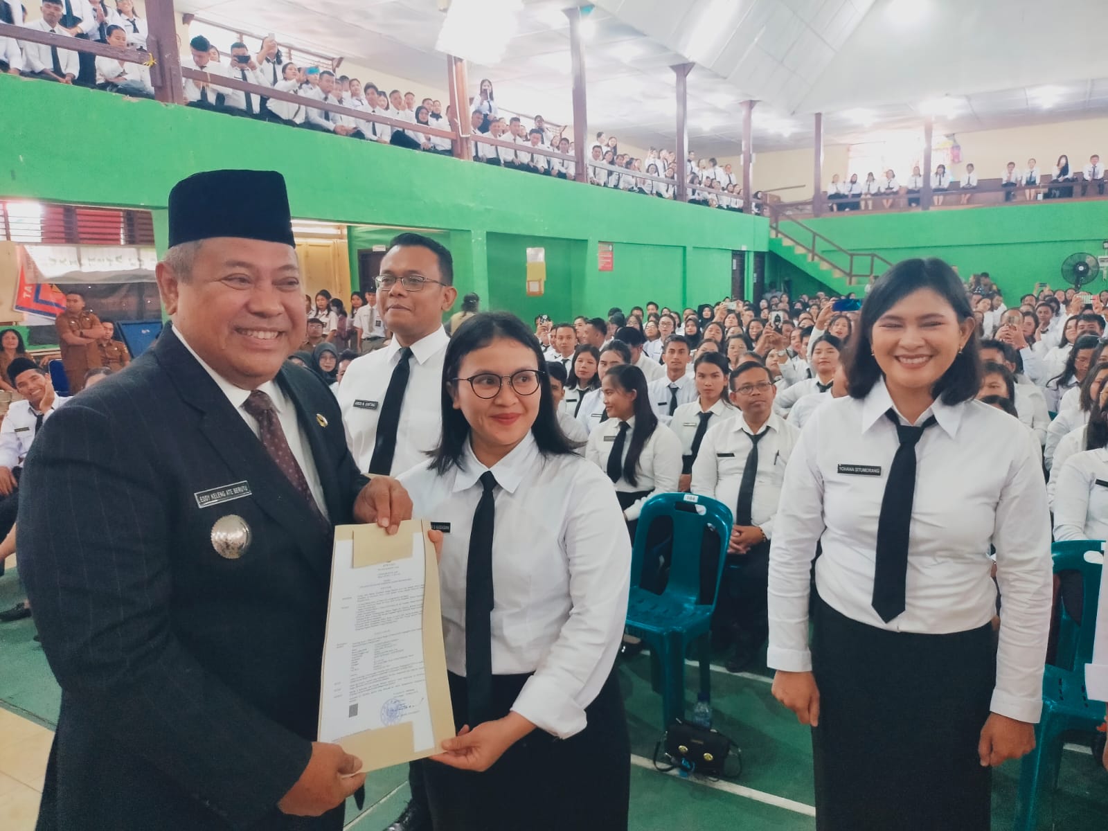 SERAHKAN: Bupati Dairi, Eddy KA Berutu serahkan SK pengangkatan kepada salahsatu tenaga honorer yang diangkat jadi PPPK di GOR Sidikalang, Senin (22/4/2024). RUDY SITANGGANG.