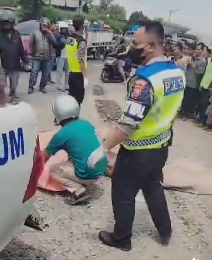 OLAH TKP: Petugas Satlantas Polres Deliserdang melakukan olah TKP peristiwa kecelakaan truk menabrak pengendara sepeda motor.