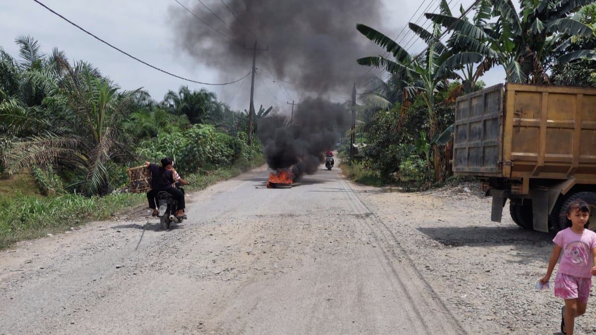 BAKAR BAN: Aksi warga bakar ban di jalan rusak Kelurahan Pekan Selesai agar segera diperbaiki.(Masyarakat Selesai/Sumut Pos )