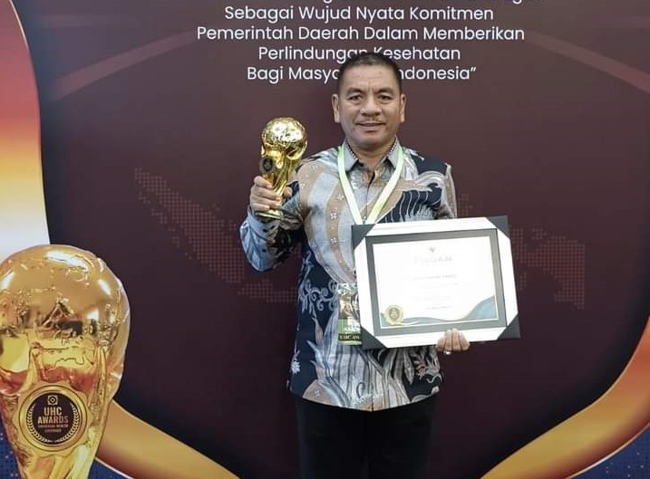 TERIMA: Plt Sekdako Tebingtinggi Kamlan Mursyid ketika menerima penghargaan Universal Health Coverage dari BPJS Kesehatan di Jakarta. (ISTIMEWA/SUMUT POS)
