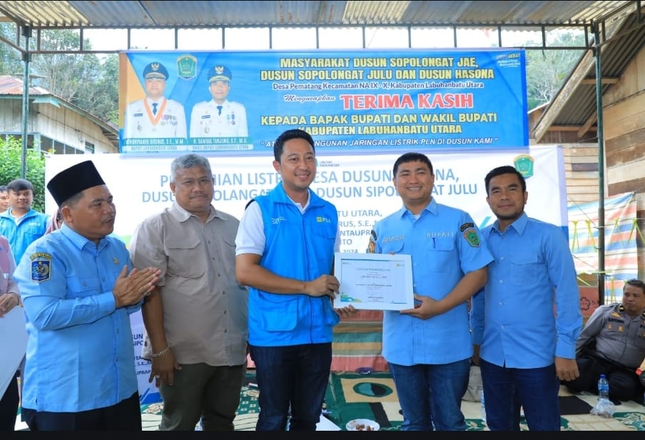 Manager PLN UP3 Rantauprapat, Sendy Rudianto (dua dari kiri) menyerahkan piagam penghargaan kepada Bupati Labuhan Batu Utara, Hendriyanto Sitorus, S.E., M.M. (dua dari kanan) di Desa Pematang,