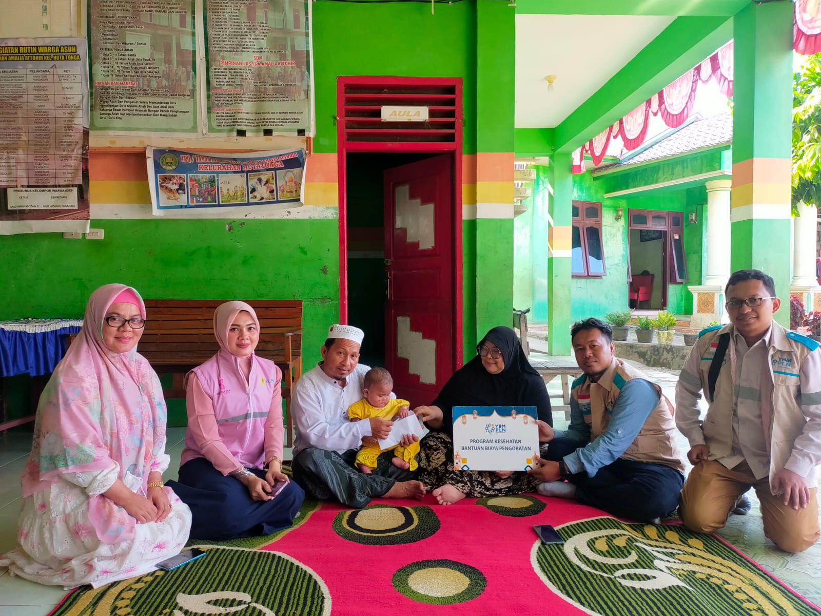 Ketua YBM PLN UP3 Padangsidimpuan, Wiwin Sapta Prabudi (dua dari kanan) menyerahkan secara simbolis bantuan biaya pengobatan kepada Aisyah Putri di Panti Asuhan Amalia Attohir, pada Sabtu (17/8).