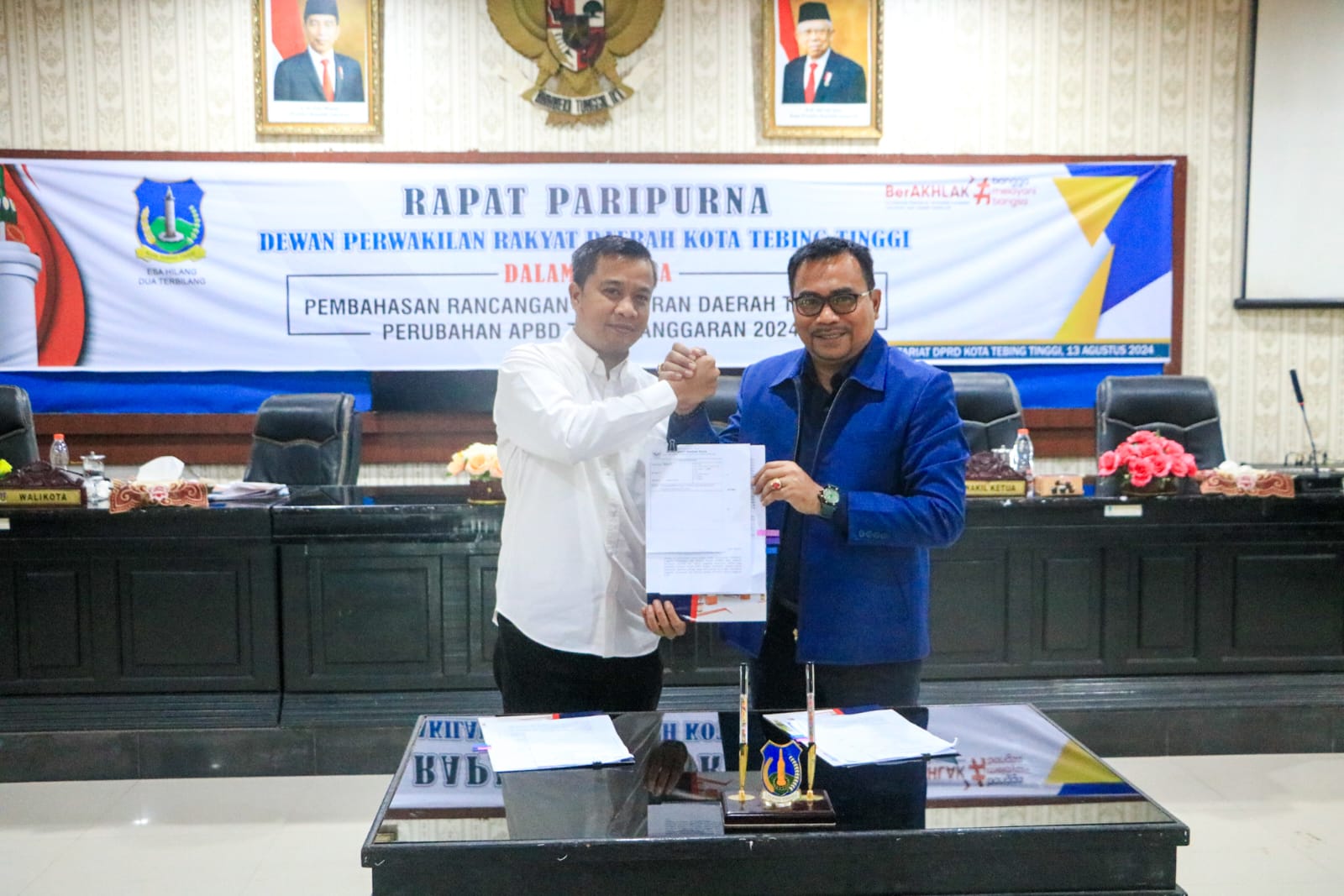 TERIMA: Pj Wali Kota Tebingtinggi Moettaqien Hasrimi ketika menerima salinan pengesahan PAPBD tahun 2024 disahkan menjadi Ranperda dari Wakil Ketua I DPRD, Muhammad Azwar. (SOPIAN/SUMUT POS)
