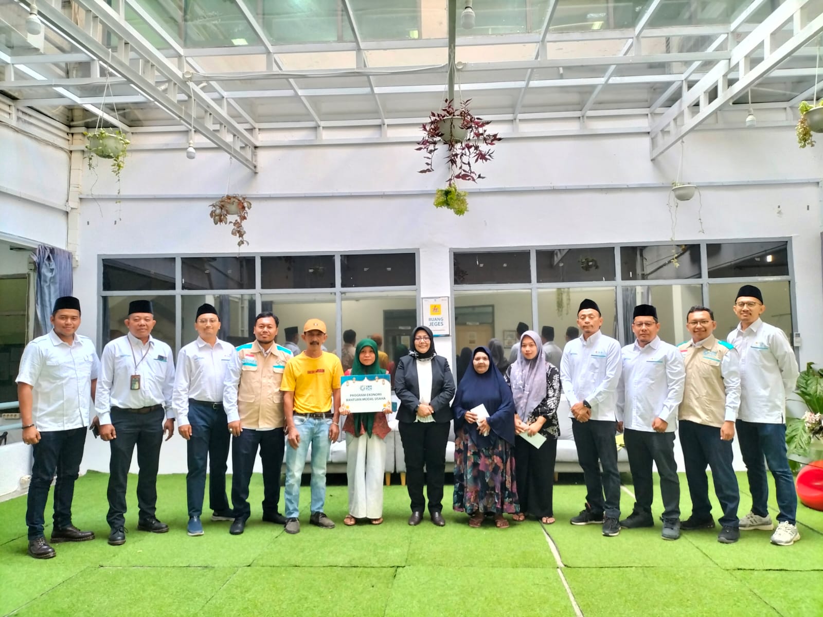 Foto bersama Management PLN UP3 Padangsidimpuan dengan keluarga  prasejahtera dalam penyaluran bantuan modal usaha.