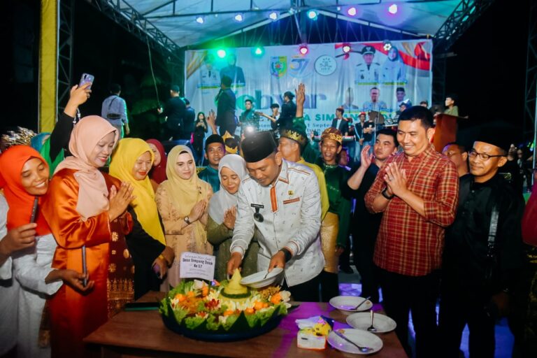 POTONG TUMPENG: Pj Bupati Batubara H Heri Wahyudi, SST,P memotong tumpeng perayaan HUT ke 57 Desa Simpang Dolok,  di Pelataran Pekan Simpang Dolok, Sabtu(31/8) malam.(LIBERTI SIHALOHO/SUMUT POS.)