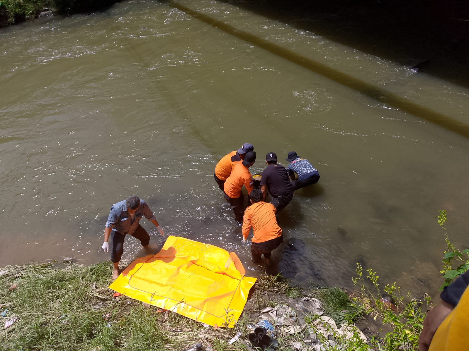 EVAKUASI: Jasad pria Mr X saat dievakuasi dari aliran sungai di bawah Titi Kembar Binjai.(Keterangan foto/Sumut Pos)