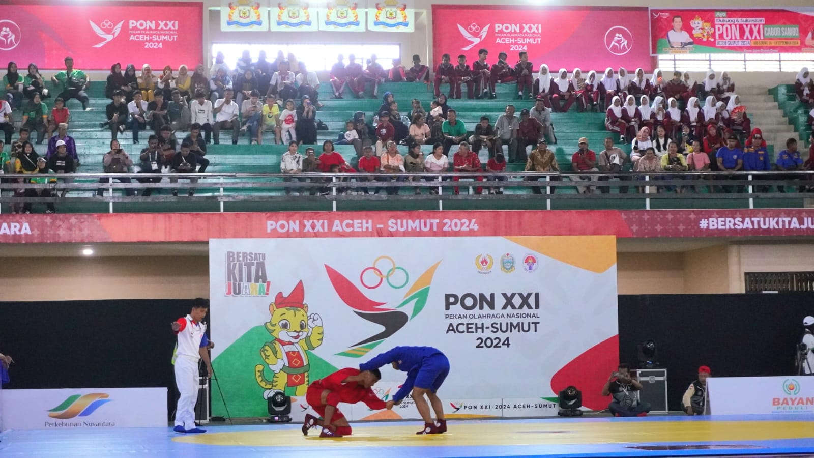 BERTANDING: Atlet sambo bertanding dalam ajang PON XXI di GOR Langkat Berseri.(Diskominfo Langkat/Sumut Pos)