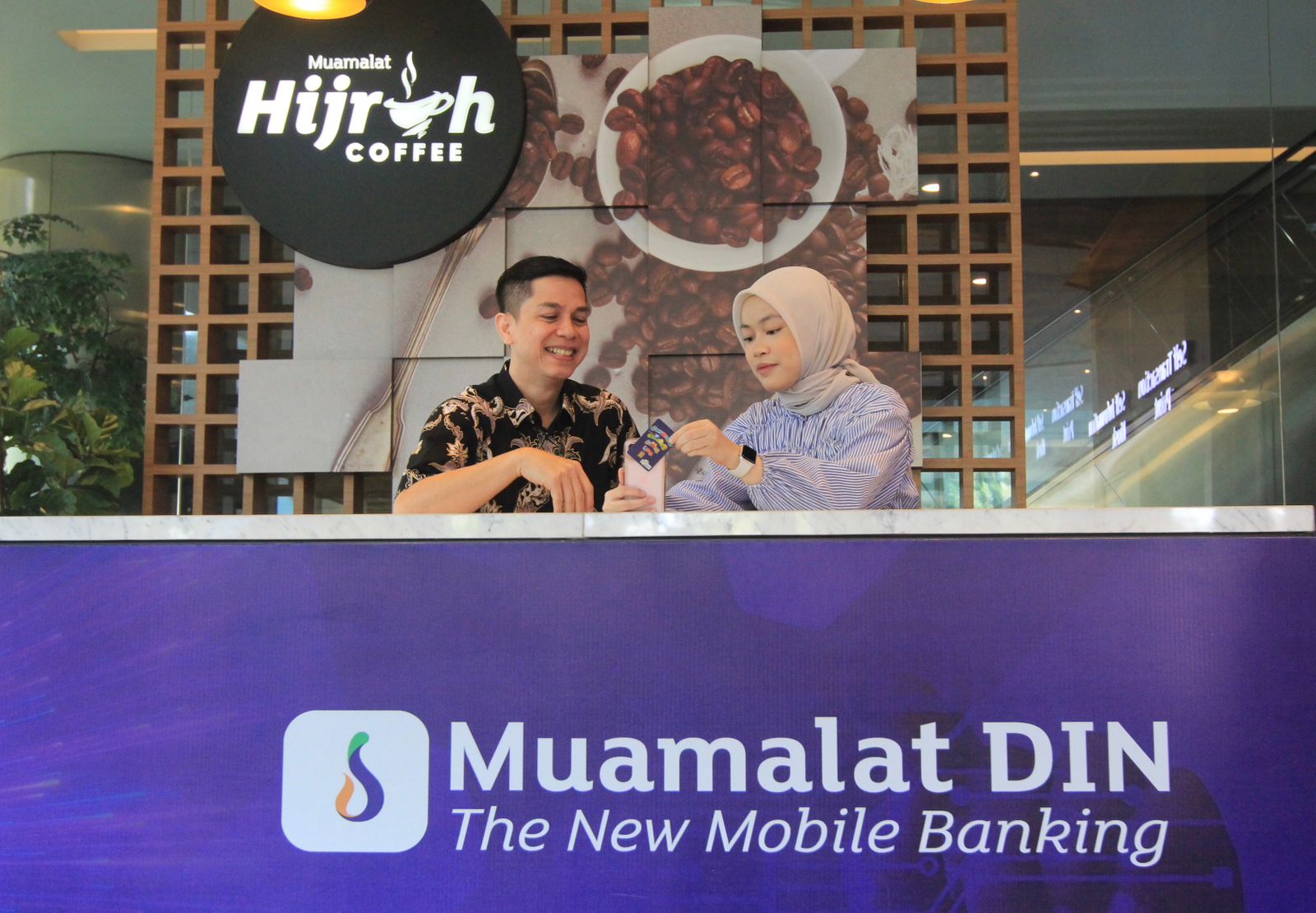 ISI ULANG: Sekretaris Perusahaan PT Bank Muamalat Indonesia Tbk Hayunaji (kiri) menjelaskan kepada nasabah cara isi ulang (top up) kartu Flazz BCA menggunakan Muamalat DIN di Jakarta.