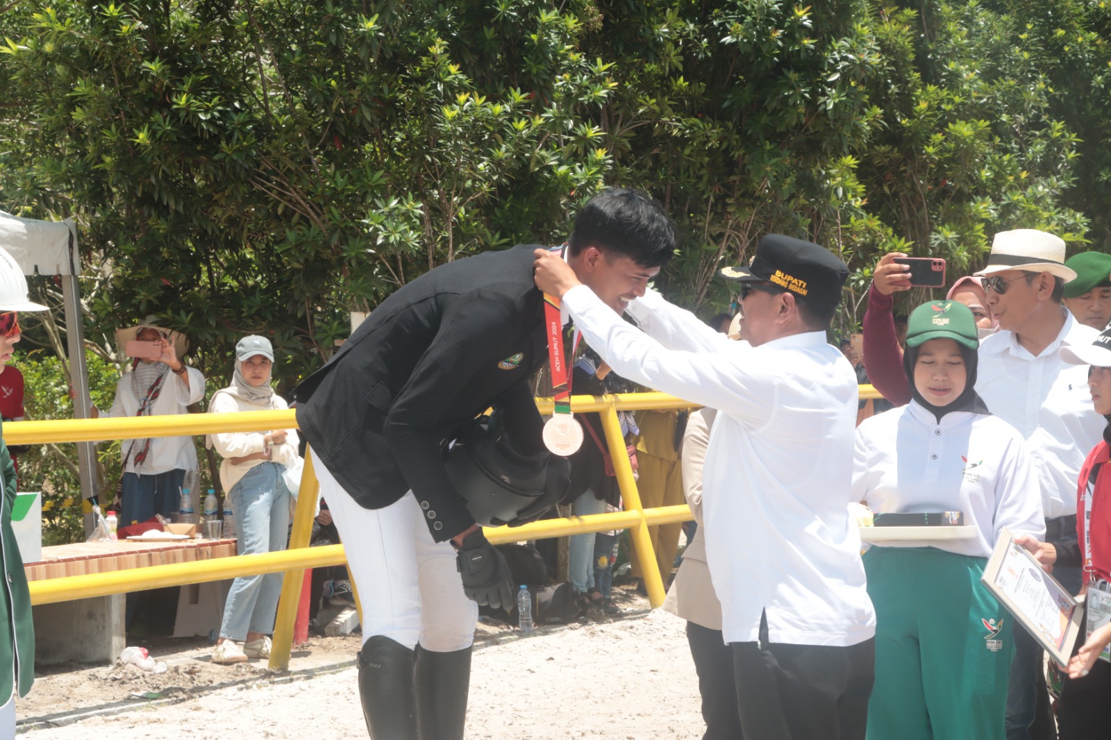 MEDALI EMAS: Bupati Serdang Bedagai H.Darma Wijaya saat mengalungkan medali emas kepada atlet Sumut Nusrtdinov Zayan Fatih di Jericho Stable,Sei Rampah ( 18/09). ( FADLY/SUMUT POS)