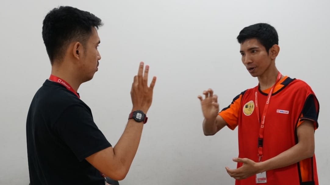 BAHASA ISYARAT: Alfamidi saat melatih karyawan bahasa isyarat.