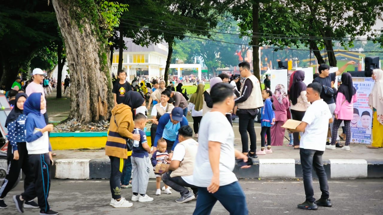 BAGI SUSU: Relawan Binjai Berdoa atau Bersama Donal Andri saat membagikan susu gratis kepada anak pada kesempatan car free day. (Teddy Akbari / Sumutpos)