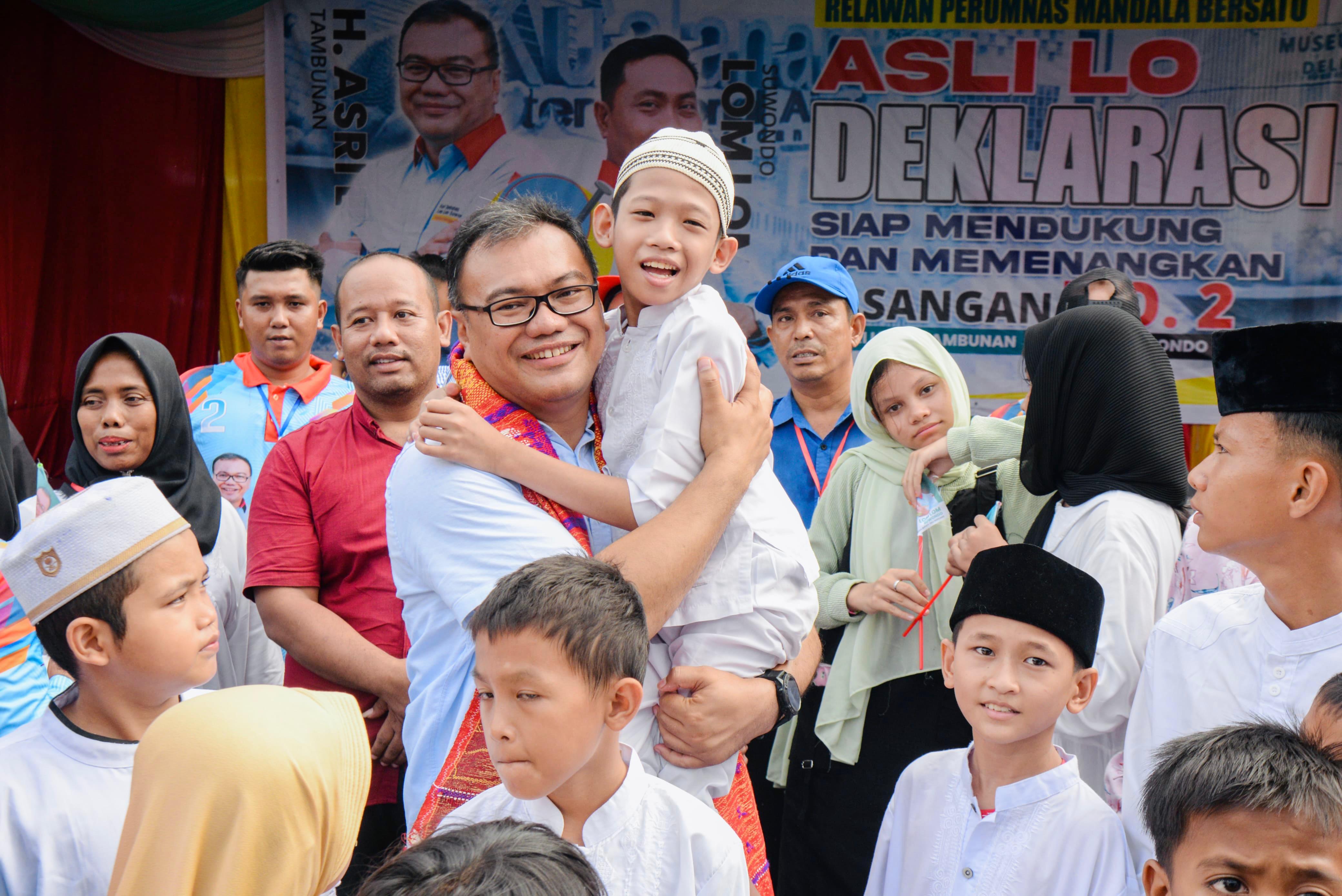 GENNDONG: Calon Bupati Deliserdang nomor urut 2 dr. Asri Ludin Tambunan  menggendong seorang anak warga saat menghadiri deklarasi Relawan Asri Ludin dan Lom Lom (Asli Lo) di lapangan cucakrawa Perumna