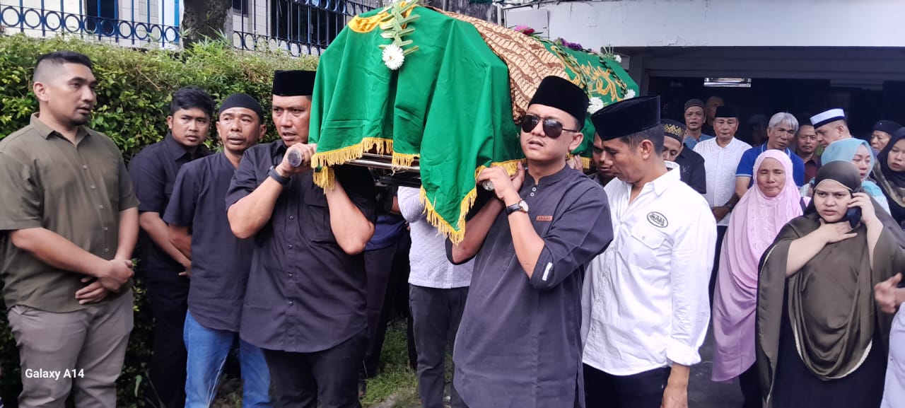 Pj Bupati Batubara Heri Wahyudi mengotong jenazah H. OK Arya Zulkarnain menuju mobil ambulance, Sabtu(2/11/2024). (Liberti)
