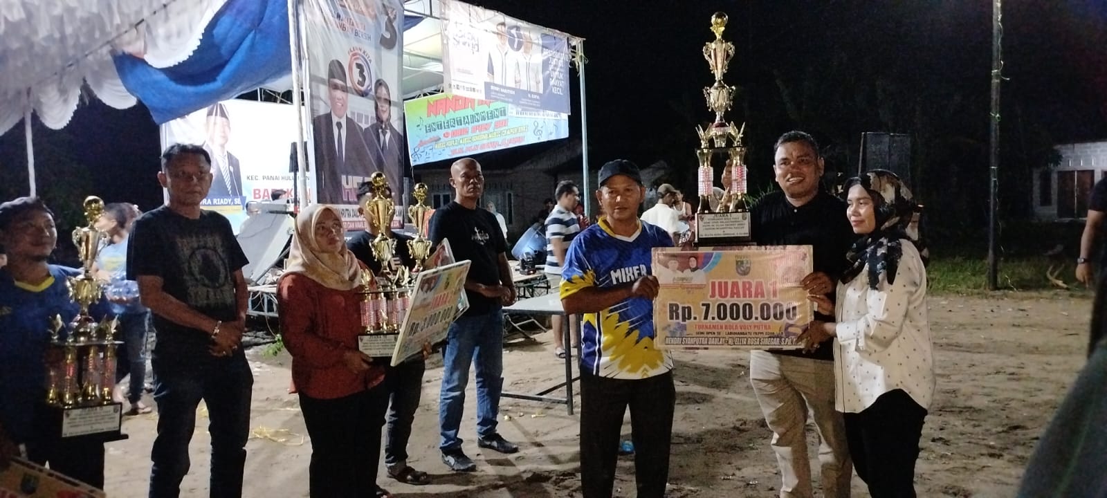 SERAHKAN: Cabup Hendri Syahputra Daulay menyerahkan trophy dan uang pembinaan juara I Turnamen Voliball Piala HERO (FAJAR/SUMUT POS)