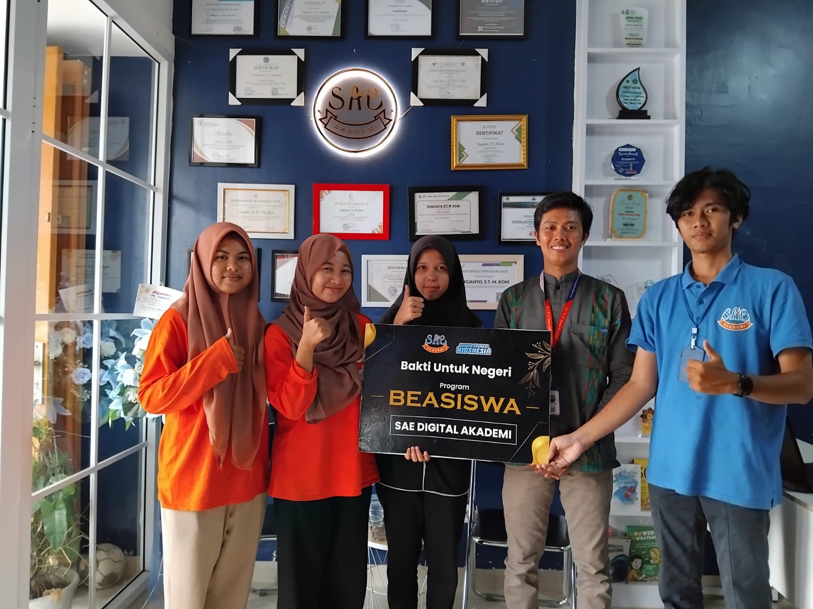 Sugianto pendiri tempatpklmedan.com (kedua dari kanan) menyerahkan beasiswa kepada tiga mahasiswa Potensi Utama&nbsp;di&nbsp;kantornya.